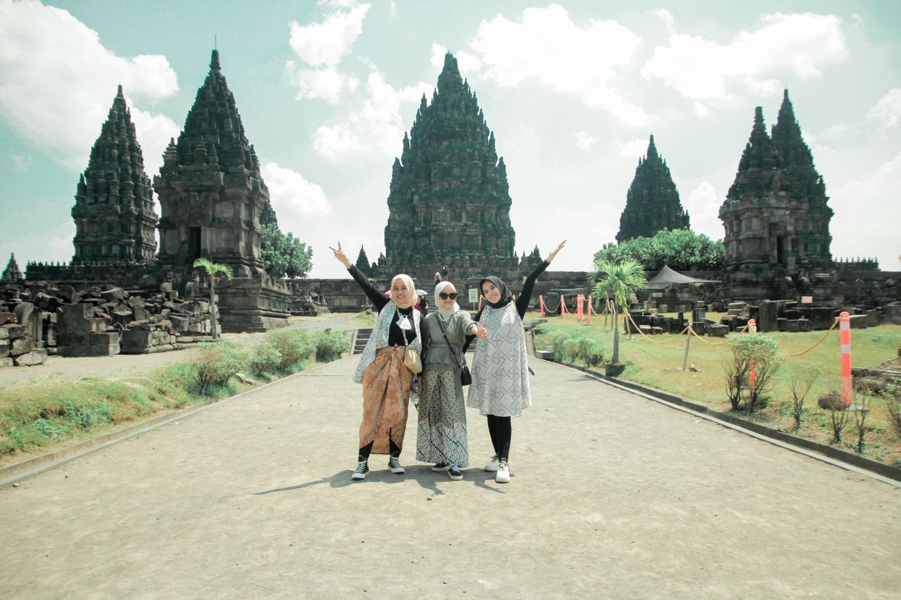 Services Three women pose happily at the historic Prambanan Temple, a cultural landmark in Jogja, Indonesia.